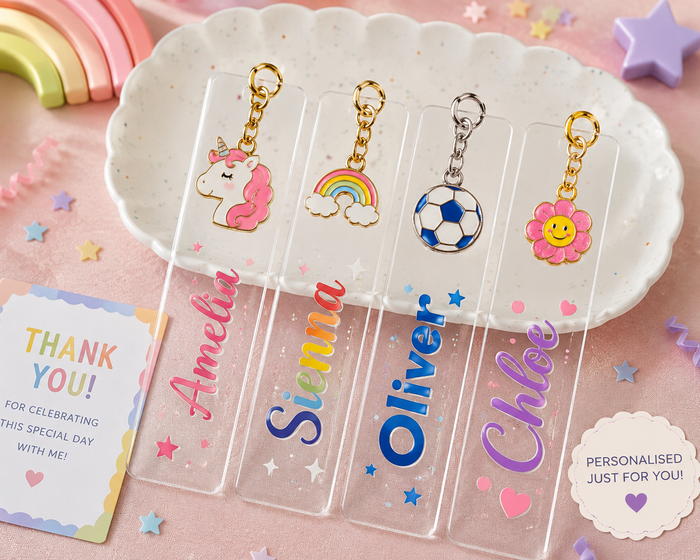 Personalised acrylic bookmark keychain favours for kids showing colourful names Amelia, Sienna, Oliver and Chloe with unicorn, rainbow, football and flower enamel charms