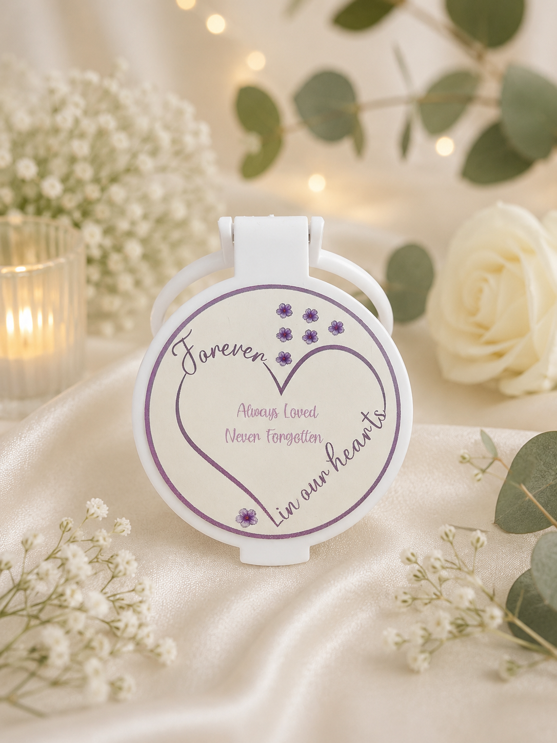 Personalised Forever in Our Hearts memorial compact mirror featuring a purple heart design, delicate flowers and a heartfelt remembrance message.